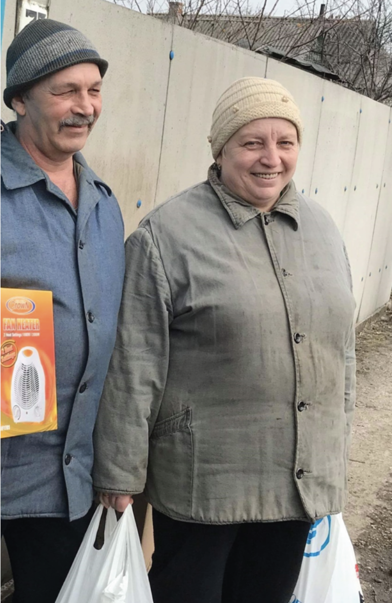 A couple is excited to receive relief packages in Avdeevka. 