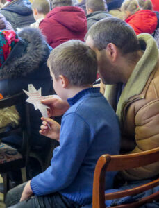 A father and son read the name on an Immanuel's Child star.