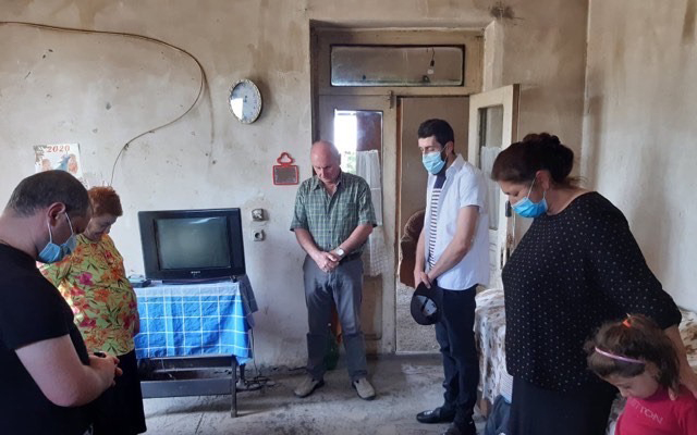 Praying with a family during a visit.