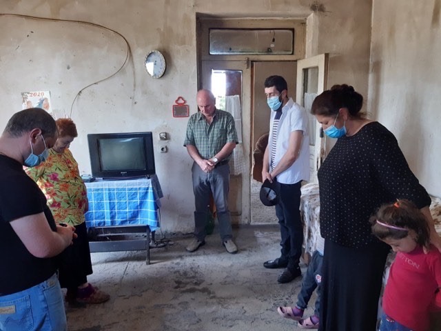 Praying with a family during a visit.