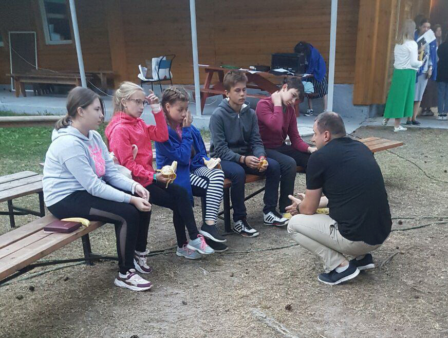 A camp leader talks with some of the children who repented and came to Christ.