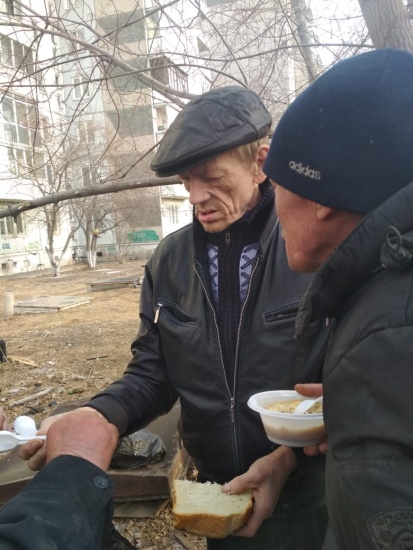 Yevgeny passes out food to men living on the street.