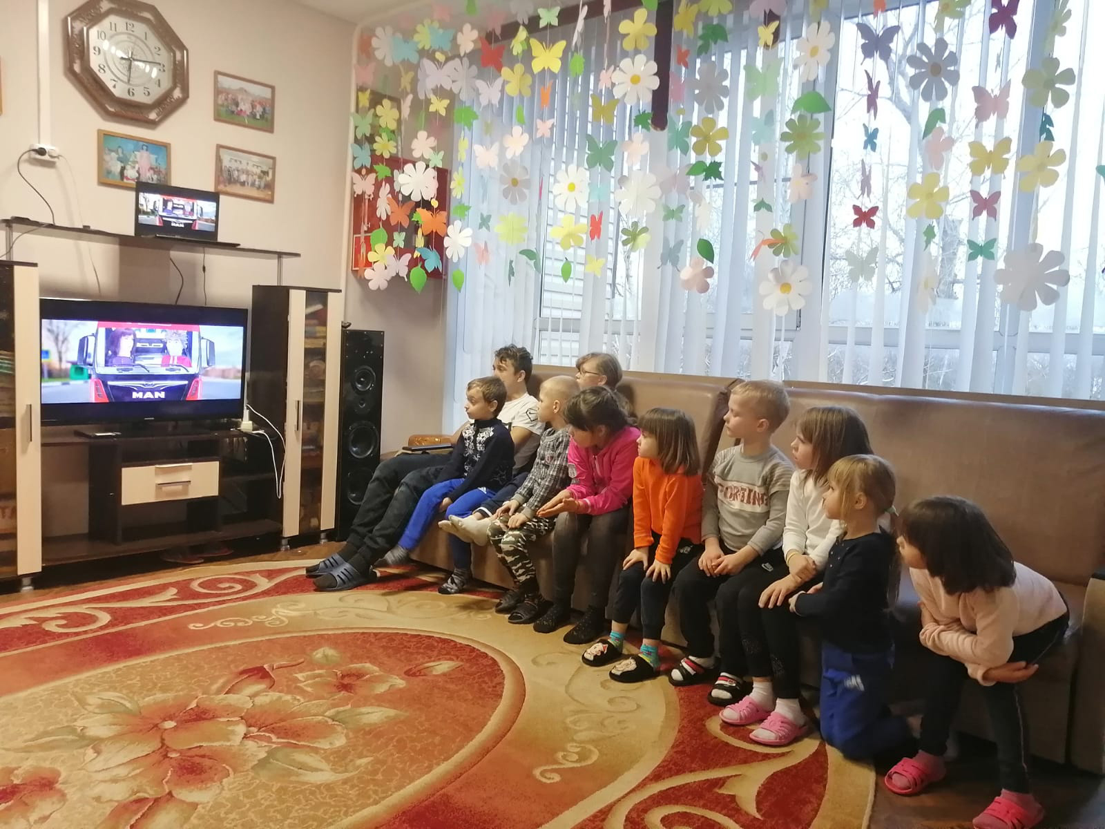 The children at the orphanage watch the recorded drama with interest.