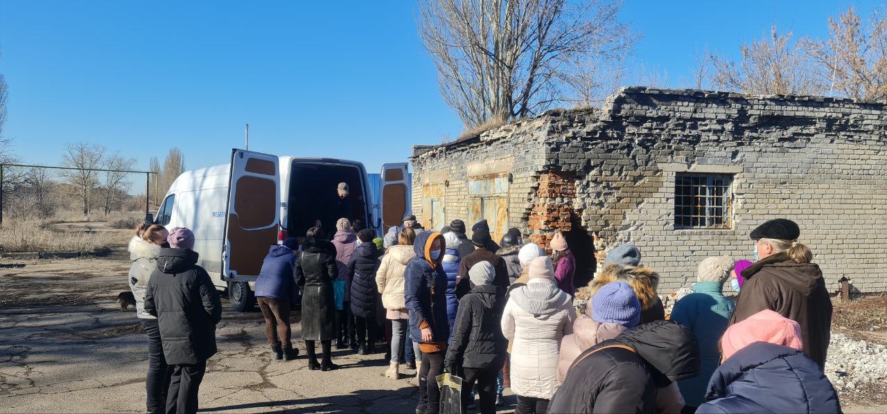 People stand in line to receive aid.