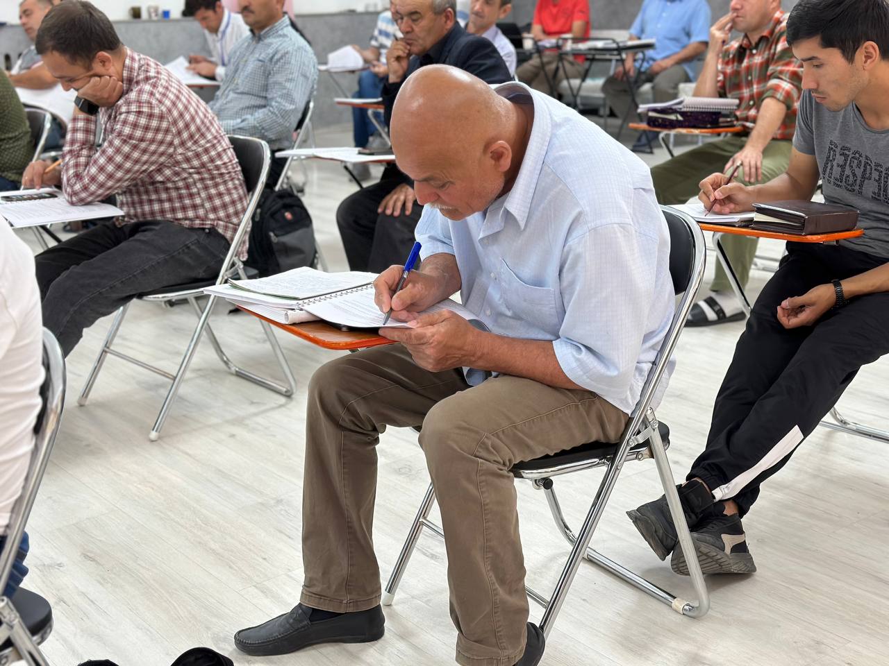 A man takes notes during a Hermeneutics class in Tajikistan.