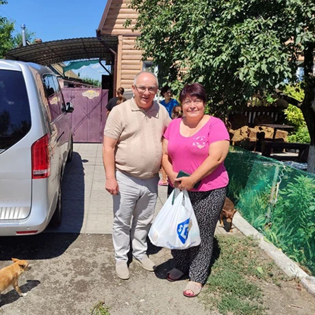 Pastor Stepan (l) brings food and the love of Christ to Nelia (r) and her family.