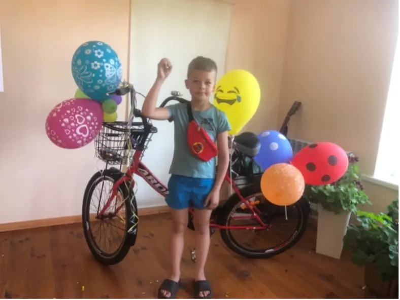 Boy standing with a bicycle