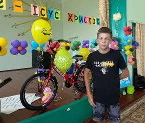 Boy standing with a bicycle